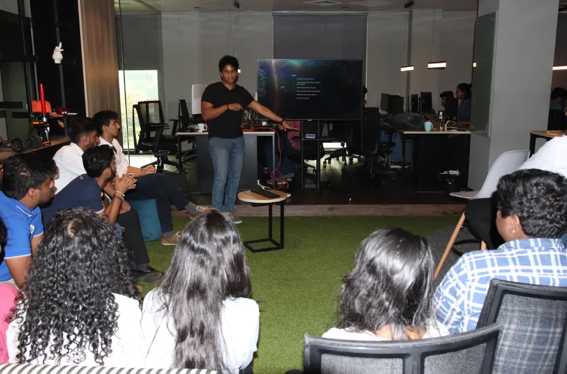 Anish speaking to a seated group at a game jam