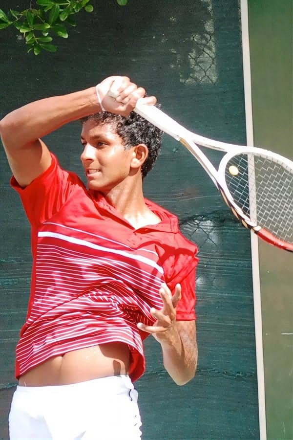 Playing a forehand in a red shirt at the Sri Lanka nationals